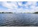 Peaceful lake view with a fountain and community houses in the background at 8435 Ocean Tides Cv, Parrish, FL 34219