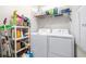 Laundry room with washer and dryer, shelving units, and various cleaning supplies at 8435 Ocean Tides Cv, Parrish, FL 34219