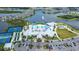 Aerial of a community pool and clubhouse complex, with tennis courts, and surrounding neighborhood at 8435 Ocean Tides Cv, Parrish, FL 34219