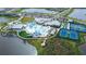 Aerial of community pool, clubhouse, tennis courts, bocce ball, and landscaping at 8435 Ocean Tides Cv, Parrish, FL 34219