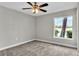 Carpeted bedroom with a ceiling fan, and a bright window overlooking the outdoor landscape providing natural light at 8640 Tahoe Ct # 16, Tampa, FL 33614