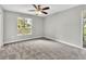 Bright bedroom features a ceiling fan, a large window and neutral colored walls and carpet at 8640 Tahoe Ct # 16, Tampa, FL 33614
