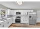 Updated kitchen with white cabinets, stainless steel appliances, and a view through the window to the outdoors at 8640 Tahoe Ct # 16, Tampa, FL 33614