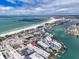 Aerial view of the condo and surrounding area with a vibrant cityscape, beach and waterways at 9715 Harrell Ave # 22, Treasure Island, FL 33706