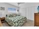 Inviting bedroom with tropical patterned bedding, ceiling fan, and closet space at 9715 Harrell Ave # 22, Treasure Island, FL 33706