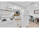 Cozy kitchen featuring white appliances, including an oven, microwave, and refrigerator at 9715 Harrell Ave # 22, Treasure Island, FL 33706