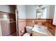 Cozy bathroom with a toilet, sink vanity, mirror and shower with pink and brown tiling at 1015 55Th S Ave, St Petersburg, FL 33705