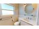 Bright bathroom with a classic white sink vanity, oval mirror, and a nearby toilet at 1015 55Th S Ave, St Petersburg, FL 33705