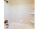 Classic white tiled bathtub with a showerhead and built-in shelving at 1015 55Th S Ave, St Petersburg, FL 33705