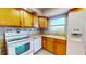 View of the bright eat-in kitchen with white appliances, tile backsplash, and ample countertop space for food preparation at 1015 55Th S Ave, St Petersburg, FL 33705
