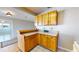 Bright eat-in kitchen features wood cabinets and bar top, with views into living room and tile floor at 1015 55Th S Ave, St Petersburg, FL 33705