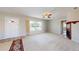 Bright living room with a large window, ceiling fan, fireplace, and neutral carpet, creating a cozy atmosphere at 1015 55Th S Ave, St Petersburg, FL 33705
