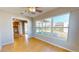 A bright living room showing the kitchen and sunroom, with wood-look flooring and natural light throughout at 1015 55Th S Ave, St Petersburg, FL 33705