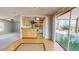 The room showcases an abundance of natural light streaming through large windows, highlighting the wood-look flooring at 1015 55Th S Ave, St Petersburg, FL 33705