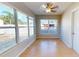 Bright sunroom featuring multiple windows, a ceiling fan, and wood-look flooring, creating a relaxing and inviting space at 1015 55Th S Ave, St Petersburg, FL 33705