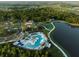 Aerial view of the community pool, clubhouse, lake, and surrounding neighborhood at 10410 Cross River Trl, Parrish, FL 34219