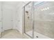 Modern bathroom featuring glass-enclosed shower, tiled walls, and a niche for storage at 10410 Cross River Trl, Parrish, FL 34219