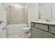 Neutral bathroom featuring a shower and bathtub combination with tiled walls and gray vanity at 10410 Cross River Trl, Parrish, FL 34219