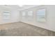 Bright bedroom with neutral carpet, white walls, three windows, and horizontal blinds at 10410 Cross River Trl, Parrish, FL 34219