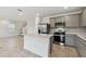 Modern kitchen features stainless steel appliances, a center island, and elegant gray cabinets at 10410 Cross River Trl, Parrish, FL 34219