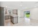 Well-lit kitchen with backyard views, stainless steel appliances, gray cabinets, and a center island at 10410 Cross River Trl, Parrish, FL 34219
