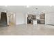 Spacious open floor plan with a staircase and modern kitchen featuring stainless appliances and a kitchen island at 10410 Cross River Trl, Parrish, FL 34219