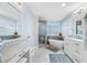 Bright bathroom features marble counters, standalone tub, and glass enclosed shower with white and grey tile at 10627 Hatteras Dr, Tampa, FL 33615