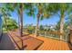 Spacious wooden deck surrounded by palm trees, perfect for enjoying the waterfront scenery at 10627 Hatteras Dr, Tampa, FL 33615