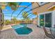 A backyard patio with a screened pool and tropical landscaping creates a serene outdoor retreat at 10627 Hatteras Dr, Tampa, FL 33615