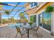 Outdoor dining area with a view of the screened-in pool and the house at 10627 Hatteras Dr, Tampa, FL 33615