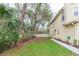 Green backyard features green lawn, a concrete path and various trees that enhance the property's appeal at 10906 Kensington Park Ave, Riverview, FL 33578