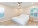 This bright bedroom features a large bed, neutral colors, and natural light from two windows at 10906 Kensington Park Ave, Riverview, FL 33578