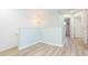 Bright upstairs hallway featuring modern chandelier, white shiplap walls, and beautiful wood floors at 10906 Kensington Park Ave, Riverview, FL 33578