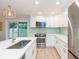 Bright kitchen features stainless steel appliances, white cabinetry, and a stylish backsplash at 10906 Kensington Park Ave, Riverview, FL 33578