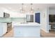 Open-concept kitchen with a large center island, modern appliances, and sleek white cabinetry at 10906 Kensington Park Ave, Riverview, FL 33578