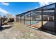 Exterior view of a screened-in pool featuring a stone deck and a black frame surrounding the enclosure at 11206 Mondale Ave, Seffner, FL 33584