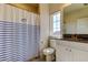Traditional bathroom with a striped shower curtain, granite countertop, and a window for natural light at 11257 Egeria Dr, Odessa, FL 33556