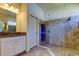 Modern bathroom featuring a walk-in shower, tile floor, and a vanity with a granite countertop at 11257 Egeria Dr, Odessa, FL 33556
