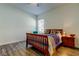 Cozy bedroom showcasing hardwood floors, a wooden bed frame, and a view of the window at 11257 Egeria Dr, Odessa, FL 33556