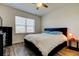 Cozy bedroom with dark wood floors, a comfy bed with blue pillows, and a bright window at 11257 Egeria Dr, Odessa, FL 33556