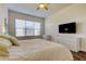 Bright bedroom with large window, ceiling fan, flat screen television and white dresser at 11257 Egeria Dr, Odessa, FL 33556