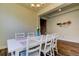Dining room with a table set for six, white chairs, tray ceiling, and wood flooring at 11257 Egeria Dr, Odessa, FL 33556