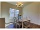 Bright dining room featuring hardwood floors and a stylish chandelier over a white table with six chairs at 11257 Egeria Dr, Odessa, FL 33556