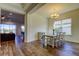 Dining room with hardwood floors, neutral walls, modern chandelier, and view of living space at 11257 Egeria Dr, Odessa, FL 33556