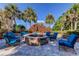 Inviting stone fire pit with comfortable blue chairs, perfect for socializing and enjoying the outdoors at 11257 Egeria Dr, Odessa, FL 33556