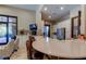 Community clubhouse kitchen featuring a long granite countertop, stainless steel fridge, and access to the outdoors at 11257 Egeria Dr, Odessa, FL 33556