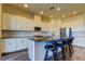 Modern kitchen with stainless steel appliances, white cabinets, a kitchen island, and barstool seating at 11257 Egeria Dr, Odessa, FL 33556