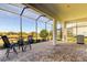 Screened patio with comfortable seating, a barbecue grill, and views of the surrounding pond at 11257 Egeria Dr, Odessa, FL 33556