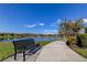 A bench overlooking a scenic community pond with walking path in a residential neighborhood at 11257 Egeria Dr, Odessa, FL 33556