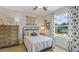 Cozy bedroom featuring a decorative dresser, patterned curtains, and a window with a view of the outdoors at 11343 Crescent Deer Dr, Land O Lakes, FL 34638